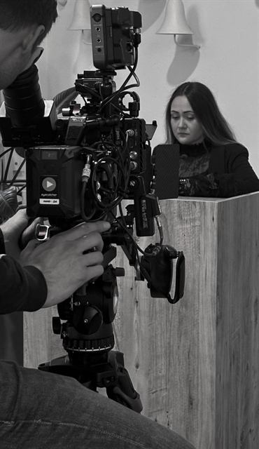 Floortje van Waardenberg tijdens opnames, achter een filmcamera